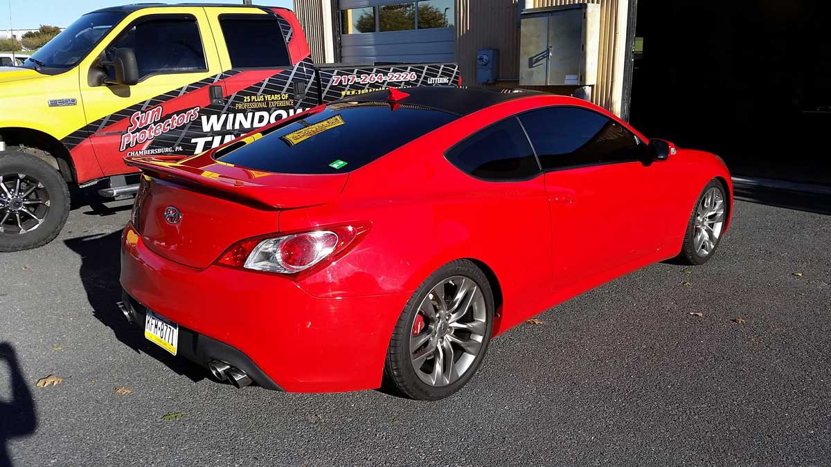 Red two-door sedan with fully tinted windows.